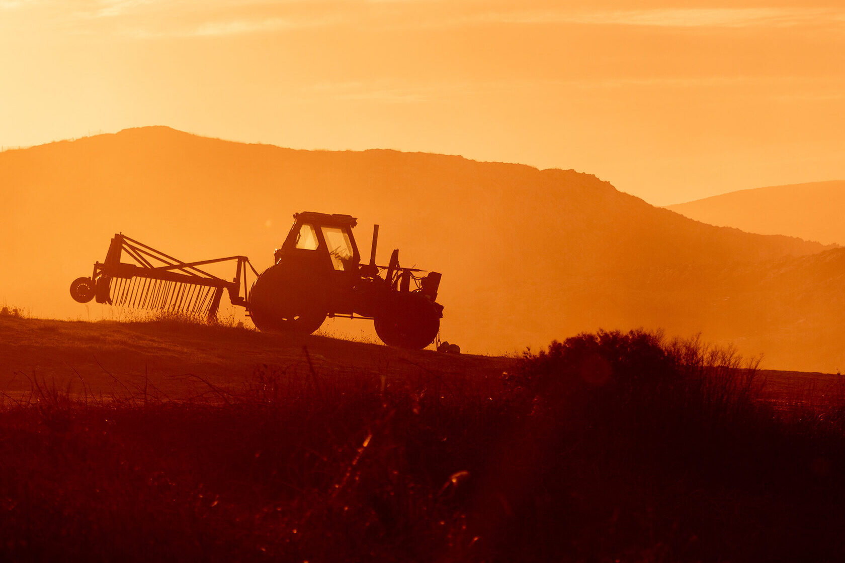 tractor-in-farm-field-at-sunset-backlight-warm-tones tractor-in-farm-field-at-sunset-backlight-warm-tones